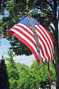 Mourning ribbon flying with an American flag