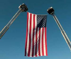 Ladders hold a flag for fallen firefighters.