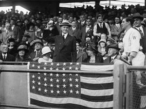 President Coolidge throws out the first pitch while Senators manager Bucky Harris looks on