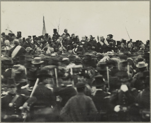 A flag hangs behind the Gettysburg crowd surrounding Lincoln. (Library of Congress)