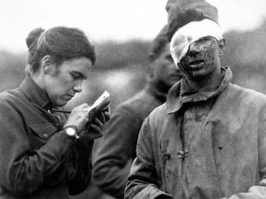 A volunteer writes a letter for a soldier wounded in WWI. (Smithsonian Institution)
