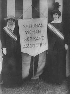 Backed by a flag, members of the National Woman Suffrage Movement hold their banner. (Library of Congress)