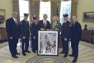 President Bush and fire personnel show off the postage stamp with the 9ll flag image