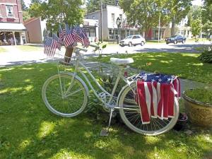 In Angelica, a bike, studded with flags, rests outside a shop. (James Breig photo)