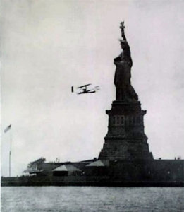 Wright flies around flag on Statue of Liberty island in 1909. (Library of Congress)