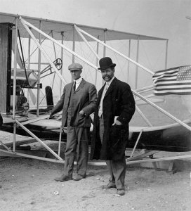 Wright poses with his plane, which carried his sister's flag. (wright-brother.org)