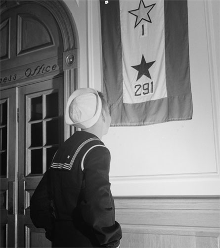 A sailor looks at a WWII service flag. (Library of Congress)