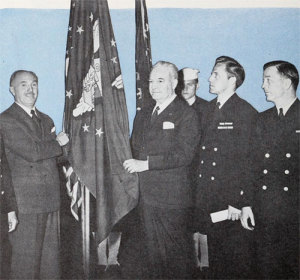 Jack Warner (left) accepts a Victory flag from the Merchant Marines