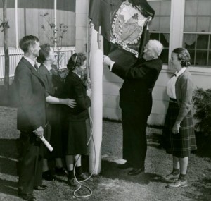 A Vermont family, circa 1940, raises their state flag. (New York Public Library)