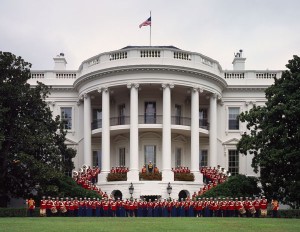 U.S. Marine Band poses at White House while a flag flies above