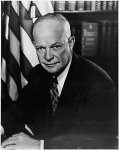 Eisenhower, backed by an American flag.
