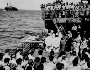 In 1943, two sailors from an aircraft carrier are covered with American flags and buried at sea in the Pacific from a Coast Guard vessel. (National Archives)