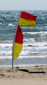 Yellow and red beach warning flags indicate a lifeguard is present
