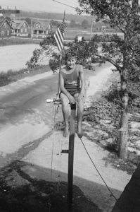 With a flag behind him, a 14-year-old Maryland youth attempts a pole-sitting record in 1929. (Library of Congress)