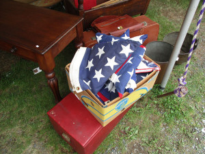 A folded flag lies among yard-sale items. (James Breig photo)