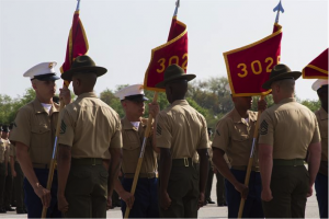 Drill instructors take guidons from graduating Marines.