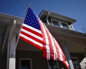 American flag on outrigger pole hanging from house