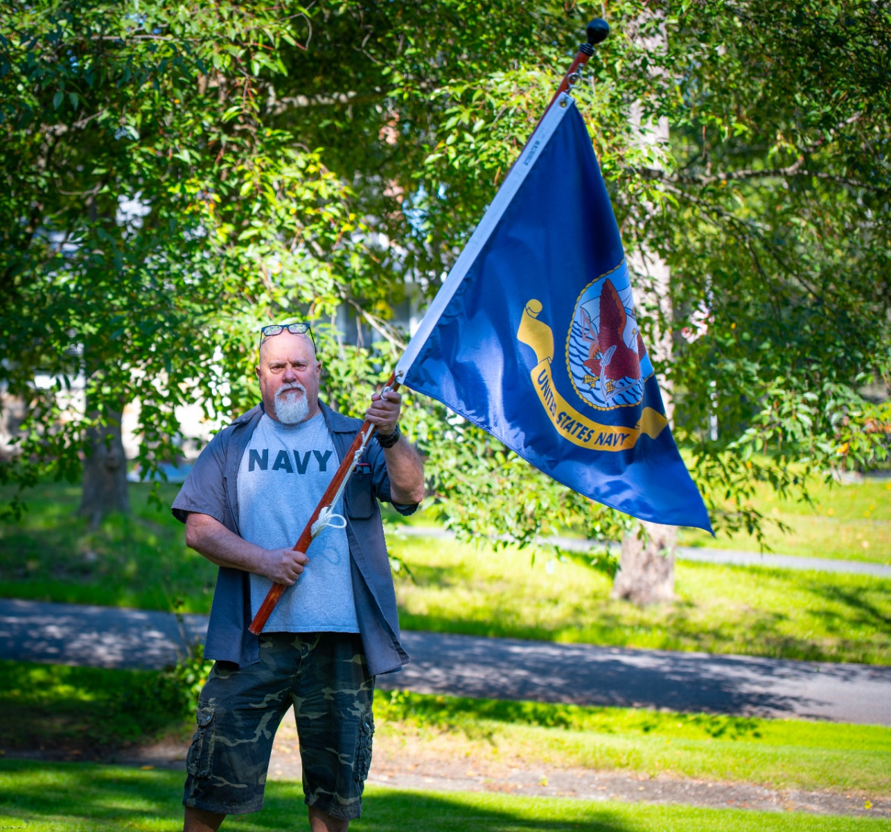 man holding US Navy flag